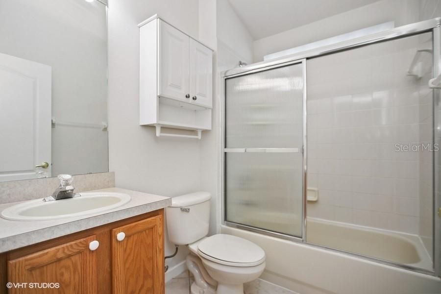 Secondary hall bath with shower doors over tub