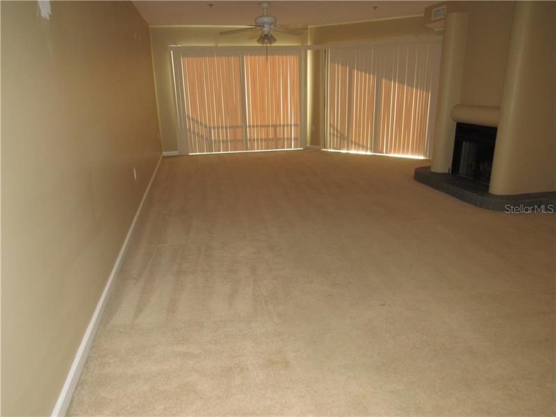 Extra large family room / den with fan, fireplace, & beautiful view of outside from the lanai.