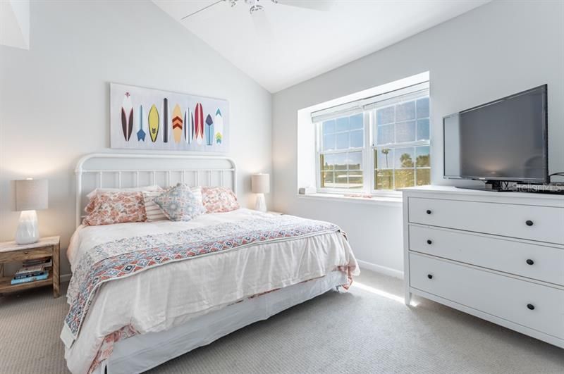 Light-filled guest bedroom offers ample closet space and an attached bathroom, which is also accessible from the hallway.