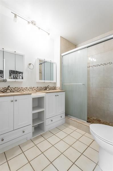 The master bathroom features double vanity with corian counters, and a newly renovated tumbled stone shower.