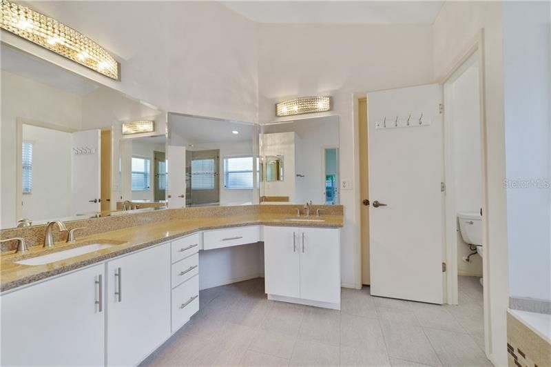 Generous MASTER BATH, also with quartz counters, an expansive DUAL SINK VANITY, GARDEN TUB and large SEPARATE FRAMELESS GLASS ENCLOSED SHOWER.