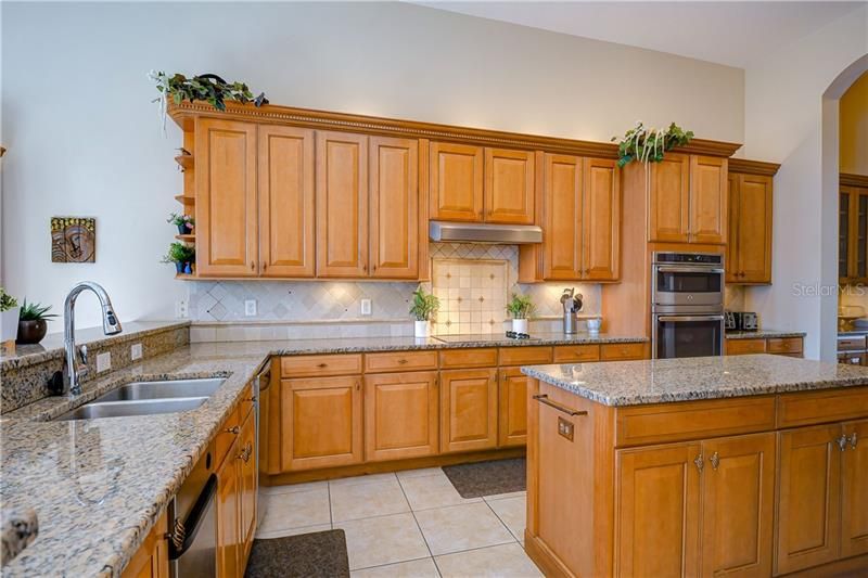 Beautiful Gourmet Kitchen with 42 inch maple cabinets, granite countertops, backsplash, separate island and sparkling stainless steel appliances.