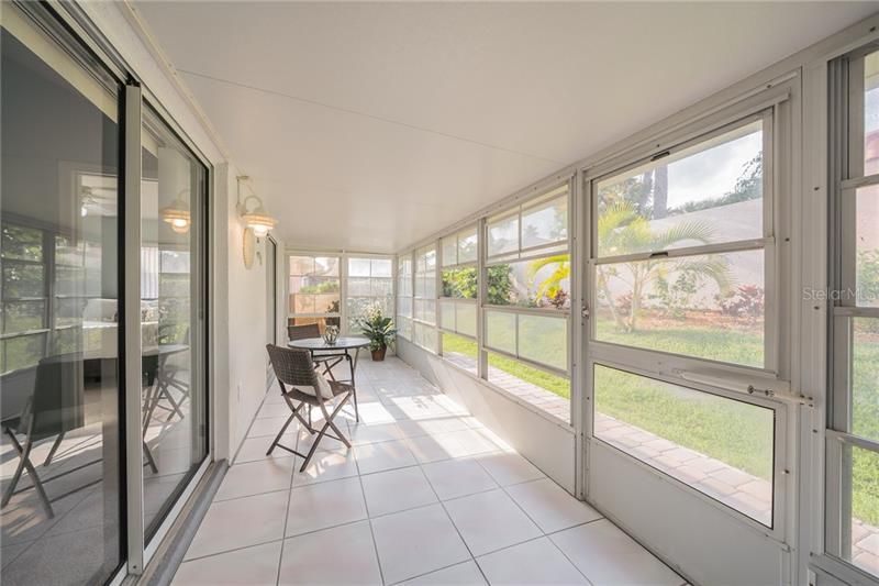 Rear enclosed tiled screened porch with movable windows to suit the weather