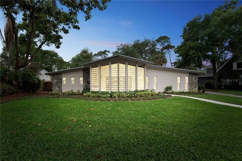 Stunning mid-century design lake front home with impressive metal breeze screen accent wall.