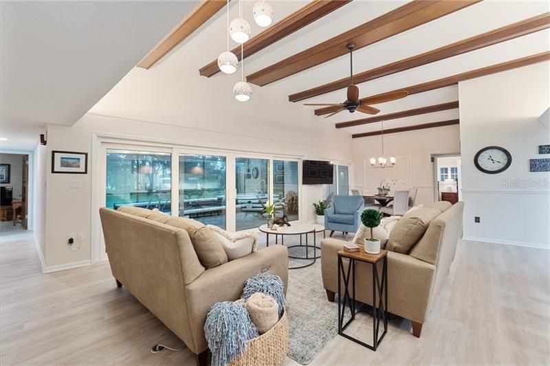 Family room with luxury vinyl planking, wood beam ceilings and stunning lake views