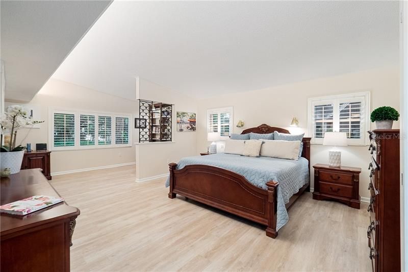 Spacious master bedroom with luxury vinyl plank flooring and a separate sitting area/study