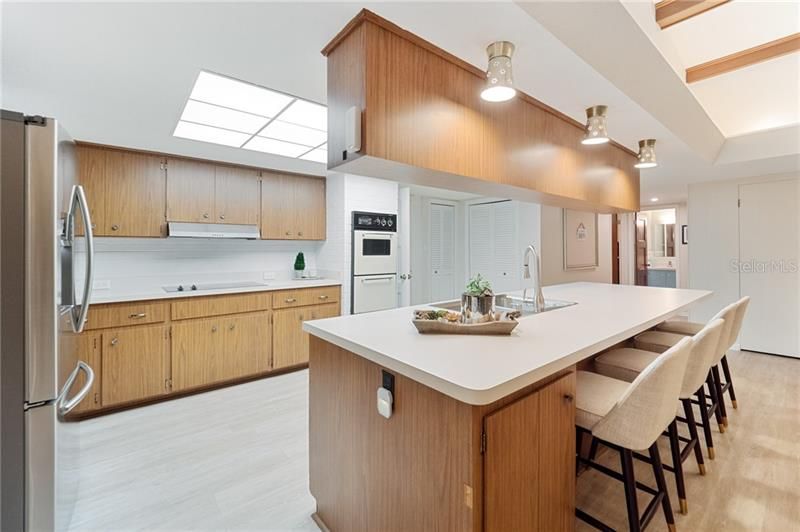 Perfect time-capsule kitchen with tons of storage, a double wall oven, breakfast bar, double closet pantries, and new (2019) stainless steel refrigerator.