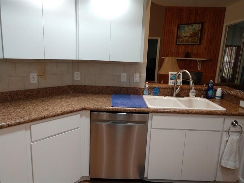 Well Lit Kitchen With Dual Sinks Towards Main Living Area