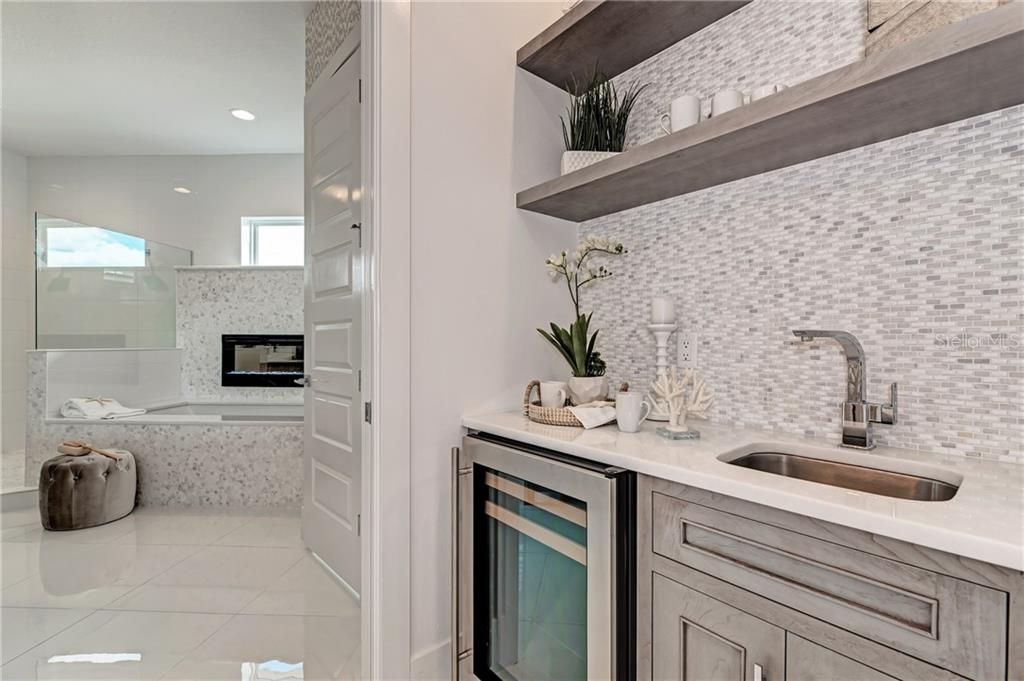 Wet bar with wine refrigerator in the Owner's Suite