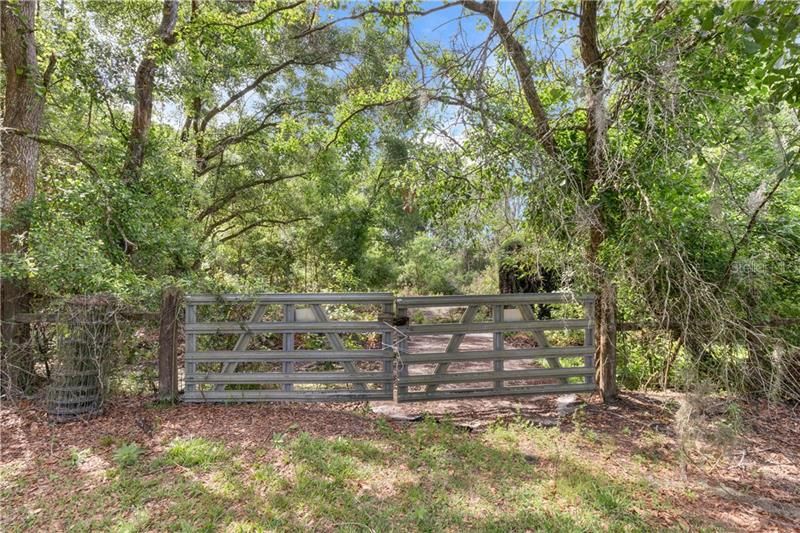 Gate to the rear of the property that has a bridge and creek!