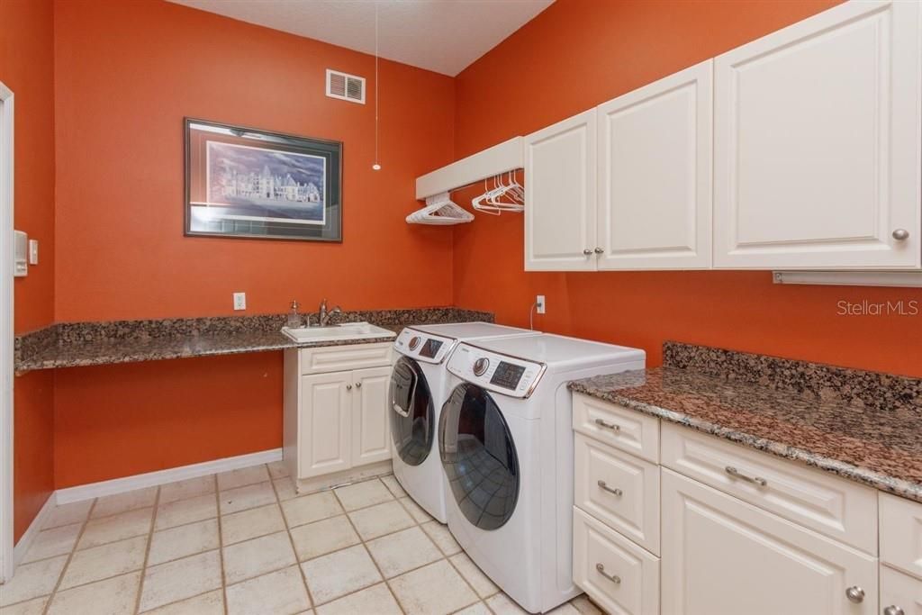 Laundry room with granite counters and plenty of storage