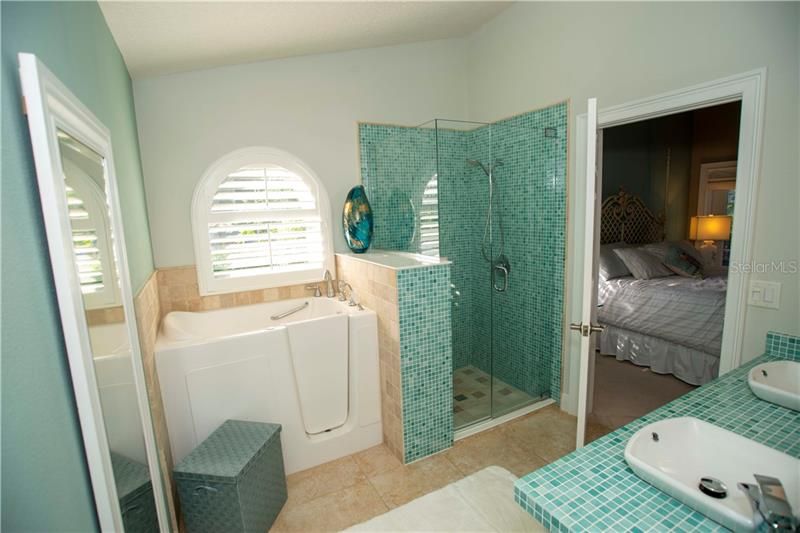 Walk in soaker tub with matching tile stand-up shower.