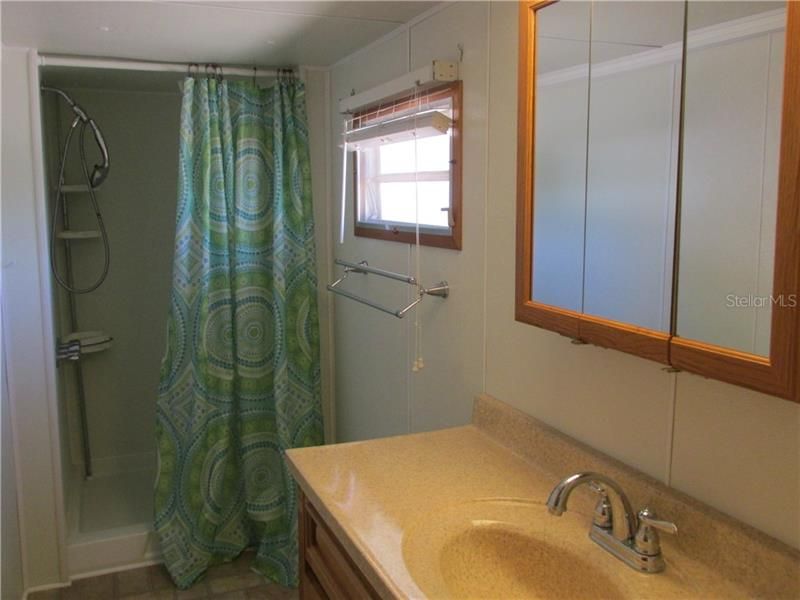 Full bathroom has a shower stall, vanity comes with solid surface counter top.