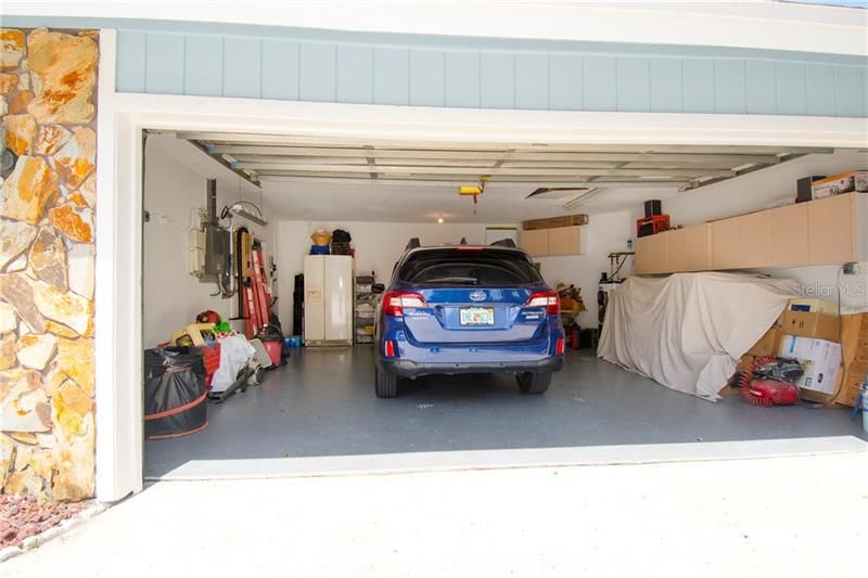 Large 22' x 23' garage with new epoxy floor and built in storage cabinets