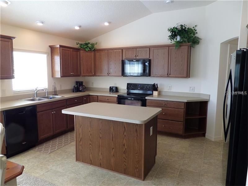 Kitchen with Vaulted ceilings, Recess Lighting, vinyl flooring and high definition beveled edge counter tops.