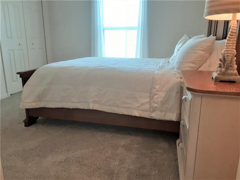 Guest bedroom 2 with Carpet flooring and vaulted ceilings.