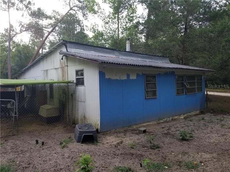 Rear of former residence-currently used for storage. Dog pens do not convey.