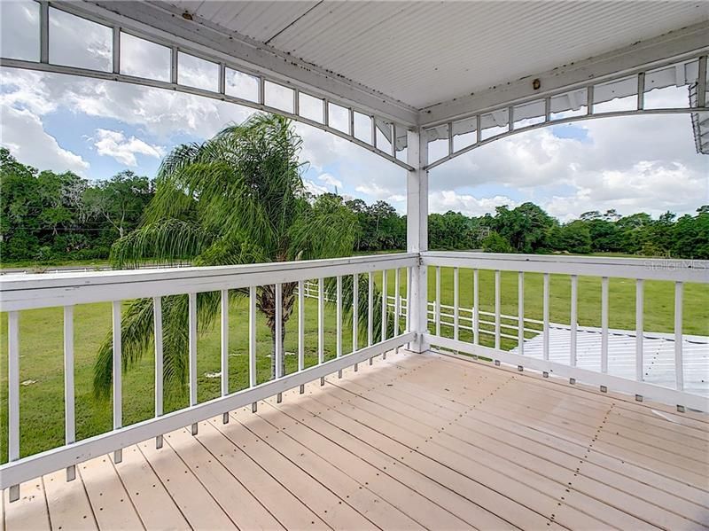 Balcony overlooking fenced pasture.