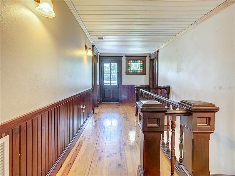 Upstairs hallway.  Balcony straight ahead.  Bedrooms on either side.