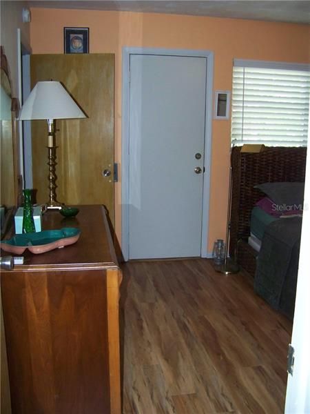 You're at the bedroom door. The white door in the back leads to a small landing area out back. The wooden door leads to the walk-in closet. Did you notice the flooring?