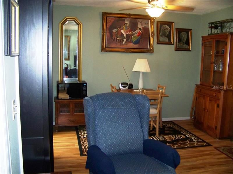 There's the dining area. The kitchen is out of view, on the left. The hall, bath and bedroom is out of view off to the right of this photo. Notice again the flooring? There is a ceiling fan over the dining area.