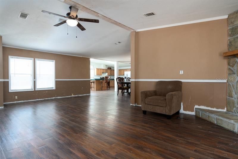 Main living area towards kitchen. Fireplace at right.