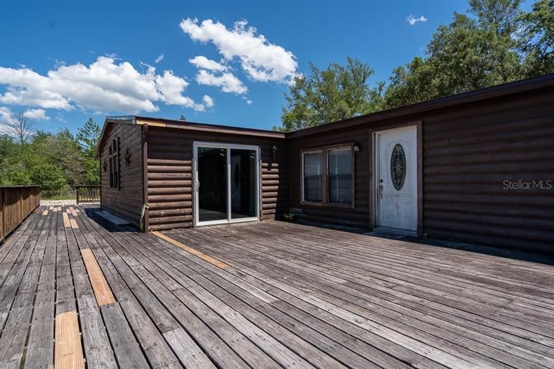 The deck runs the entire length of the home. Some boards have been replaced.