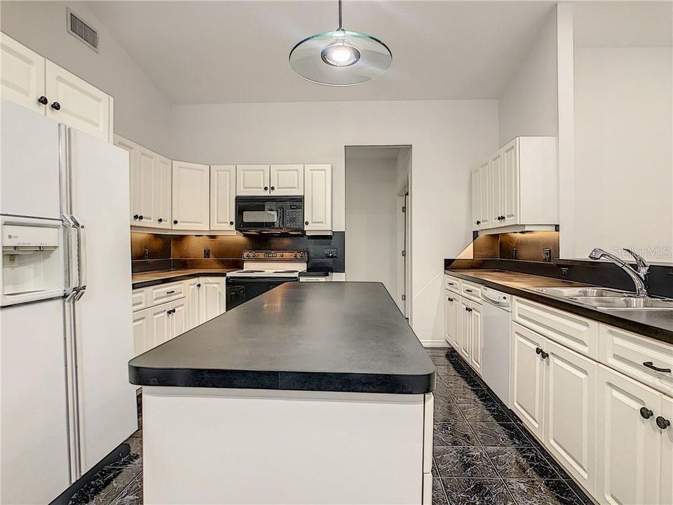 Light and bright large kitchen with movable island. Under cabinet, recessed and pendant lighting.