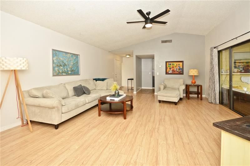 Large Family Room with  brand new fan and newer vinyl laminate flooring.