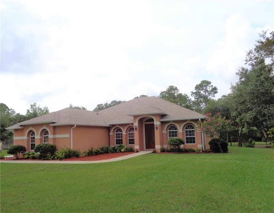 Front exterior with manicured landscaping.