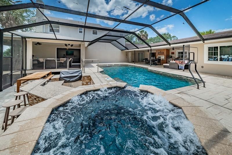 Sit in your spa and relax or swim in your heated pool near the outdoor kitchen with a grill.