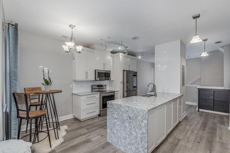 Stunning quartz counter tops with waterfall edge, eat in kitchen, dual sided peninsula. Beautiful new floors