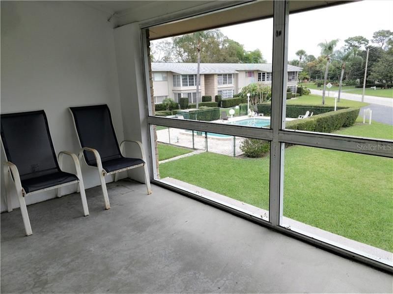 Screened Florida room with view of community pool