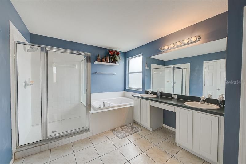 Master bathroom with double sink vanity, walk-in shower and garden bath tub.