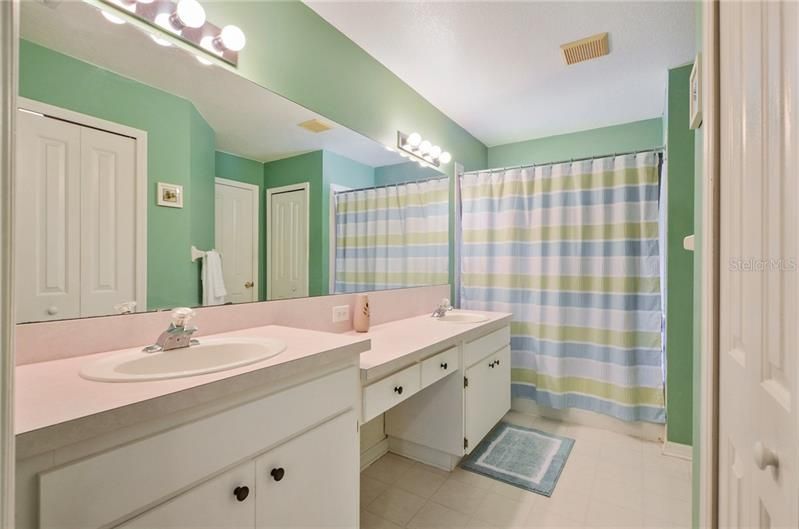 Master bath featuring dual vanity, makeup desk, walk in closet, water closet, linen closet and shower/tub combo
