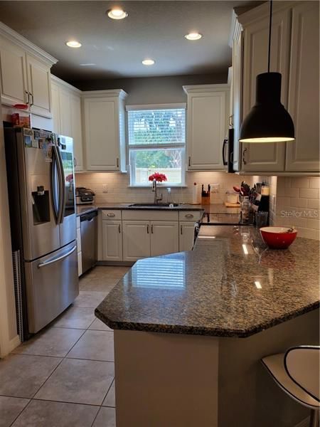 Kitchen with granite counter tops, 42" cabinets, under cabinet lighting, Stainless Steel appliance.
