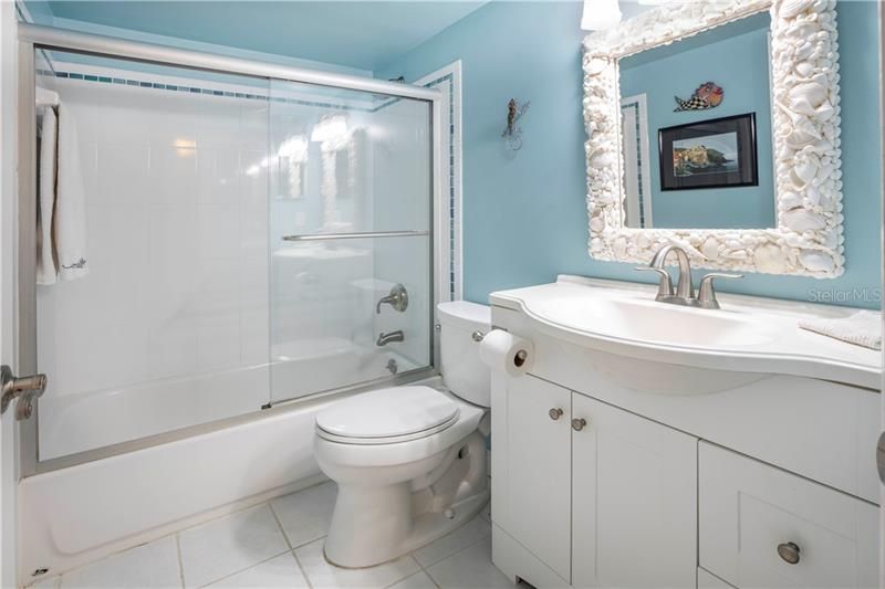 Guest bath with updated cabinet and shell framed mirror