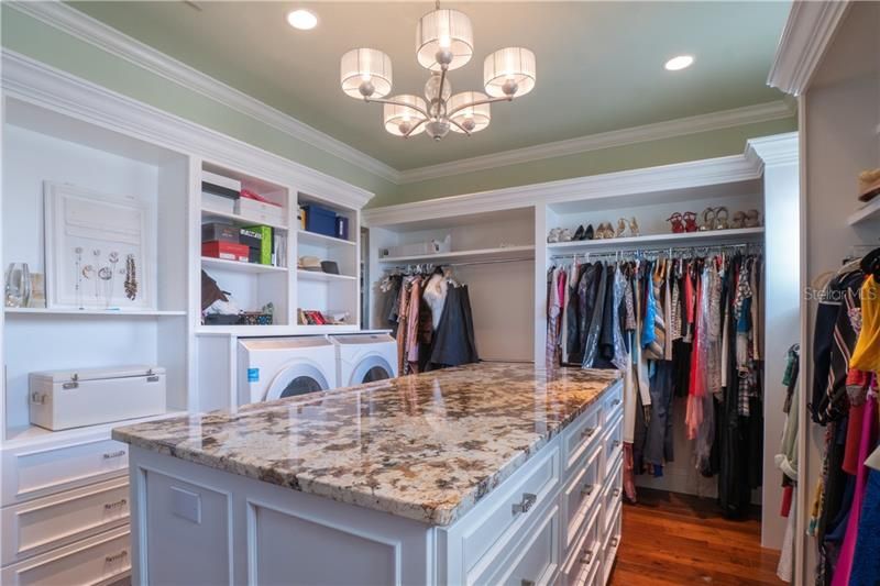Elevator or stair access to the Master Suite.  Custom master closet built for two with private full size washer and dryer. Stone surface island ideal for folding.