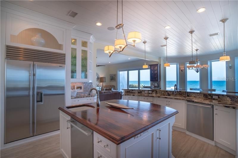 Kitchen boasts coastal elegance with detailed tongue and groove wood ceilings, specialty island counter made of Goncalo Alves wood aka (Tigerwood).  46+ inch cabinets with lighted detail, chef grade appliances, double sinks, and that view!
