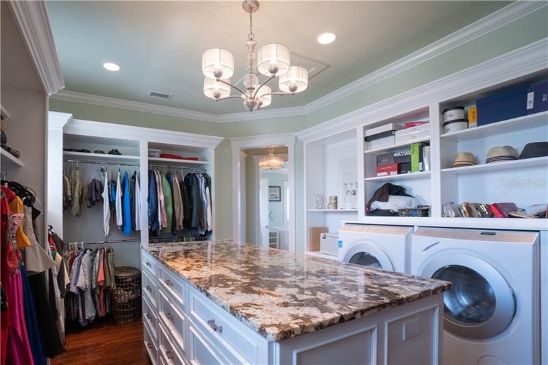 Elevator or stair access to the Master Suite.  Custom master closet built for two with private full size washer and dryer. Stone surface island ideal for folding.