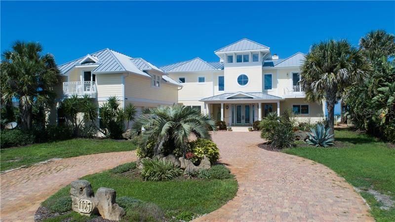 Exterior Key West architecture, spectacular ocean view,  metal roof, non drive side of Ormond Beach, 3 car detached side entry garage with apartment above, circular driveway.