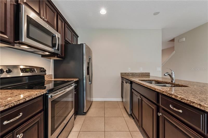 The family chef will have no trouble preparing a meal in the well equipped kitchen boasting beautiful dark SOLID WOOD CABINETS, GRANITE COUNTERTOPS, STAINLESS STEEL APPLIANCES and an extensive peninsula with BREAKFAST BAR seating for casual dining!