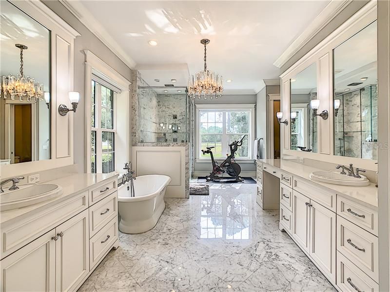 YOUR MASTER BATHROOM WITH BEAUTIFUL MARBLE TILE, HIS AND HER VANITIES, CUSTOM CABINETS WITH TONS OF STORAGE, SOAKING TUB AND AN AMAZING SHOWER THAT HAS ELECTRONIC SETTINGS FOR TEMPATURE CONTROL.