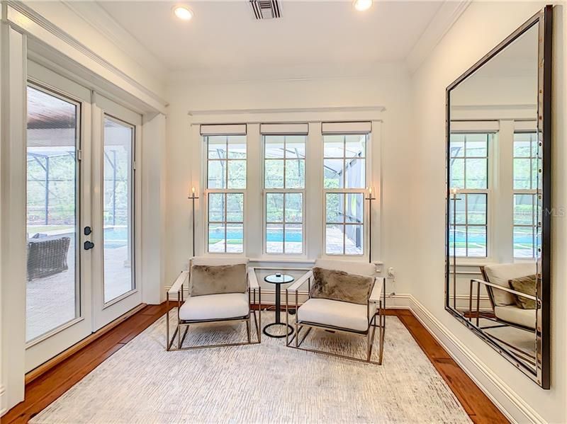 SITTING AREA IN THE MASTER BEDROOM SUITE WITH DOORS TO THE OUTSIDE ENTERTAINING AREA.