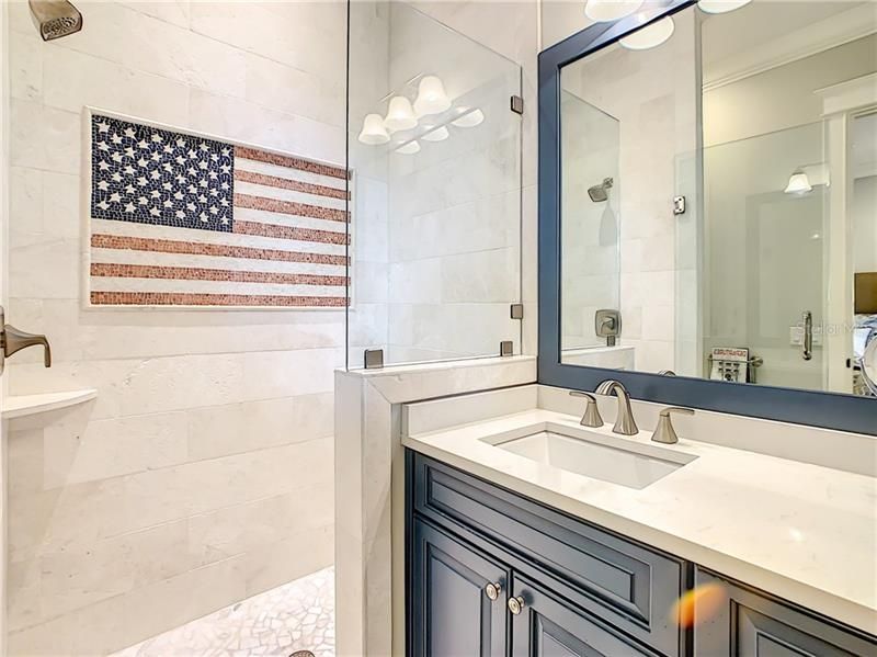 BEAUTIFUL FULL BATHROOM ATTACHED TO THE DOWNSTAIRS BEDROOM. CUSTOM BUILT CABINETS, AND CUSTOM TILE AMERICAN FLAG IN THE SHOWER!!!