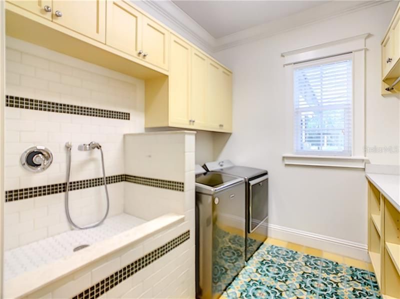 OFF THE KITCHEN AREA IS THE LAUNDRY ROOM WITH A PET WASHING STATION, TONS OF STORAGE AND COUNTER SPACE. BEAUTIFUL INLAID TILE WORK