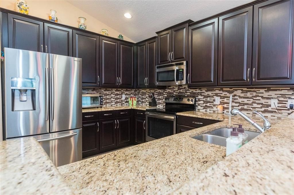 Kitchen with 42" expresso cabinets with crown molding and handles