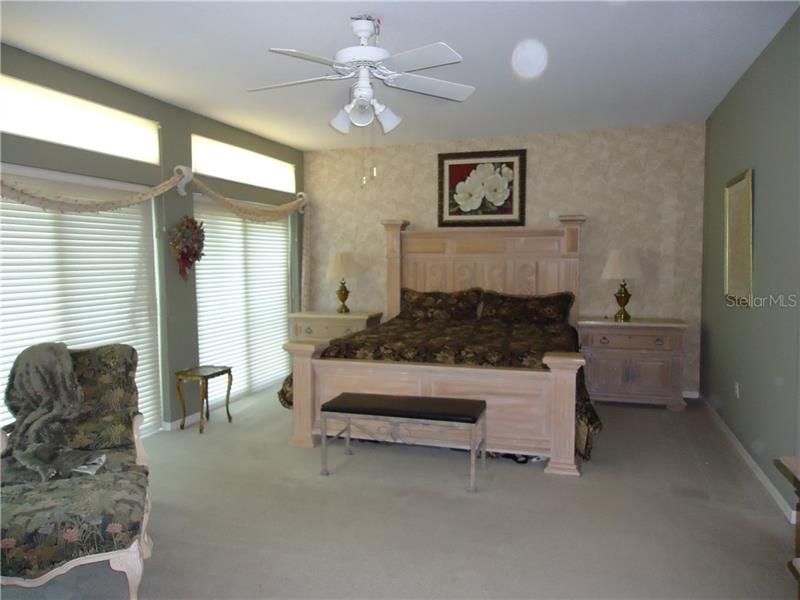 Master bedroom with king bed and blinds closed.
