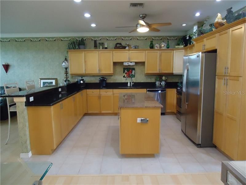 Kitchen with maple cabinets and granite countertops with stainless appliances.