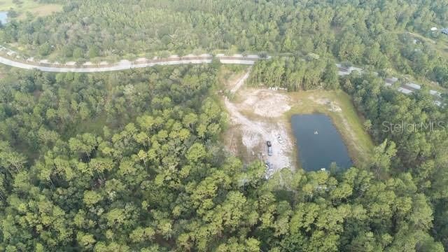 Most recent drone shot of front acreage - land cleared and raised for homestead upper left of pond, left of pond is area cleared for barn also raised.